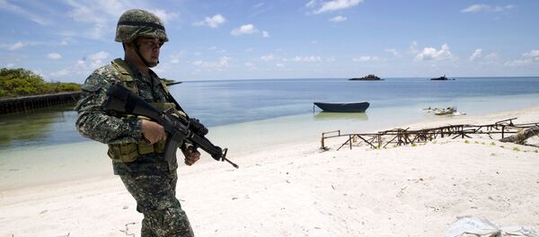 A Filipino soldier patrols at the shore of Pagasa island (Thitu Island) in the Spratly group of islands in the South China Sea, west of Palawan, Philippines, May 11, 2015. A Filipino soldier patrols at the shore of Pagasa island (Thitu Island) in the Spratly group of islands in the South China Sea, west of Palawan, Philippines, May 11, 2015. - Sputnik International
