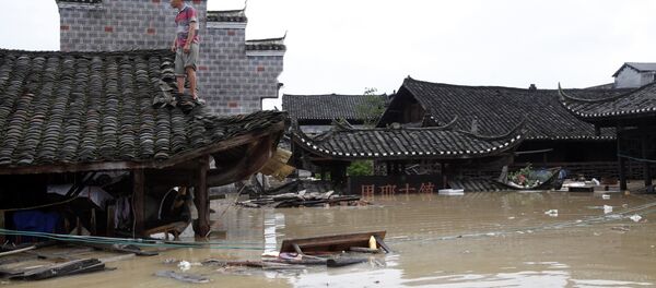 Man standing on the rood of a flood-inundated building in the flooded ancient town of Longshan county, central China's Hunan province Man standing on the rood of a flood-inundated building in the flooded ancient town of Longshan county, central China's Hunan province - Sputnik International