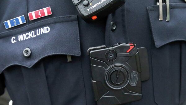 Police officer wearing a body camera beneath his microphone - Sputnik International