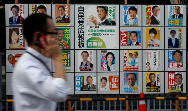 A man walks past Japan's ruling Liberal Democratic Party's (LDP) poster (C) for the July 10 upper house election with the image of Shinzo Abe, Japan's Prime Minister and leader of the LDP, and other candidates' posters at the LDP headquarters in Tokyo, Japan July 10, 2016 A man walks past Japan's ruling Liberal Democratic Party's (LDP) poster (C) for the July 10 upper house election with the image of Shinzo Abe, Japan's Prime Minister and leader of the LDP, and other candidates' posters at the LDP headquarters in Tokyo, Japan July 10, 2016 - Sputnik International