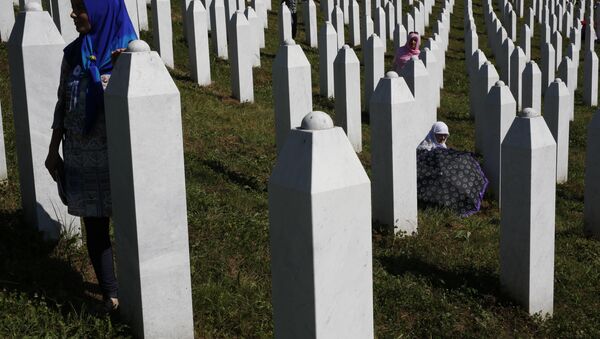 A Bosnian woman prays next to a coffin containing the remains of her relative perished in the Srebrenica massacre, during a funeral ceremony for the 127 victims at the Potocari memorial complex near Srebrenica, 150 kilometers (94 miles) northeast of Sarajevo, Bosnia and Herzegovina, Monday, July 11, 2016 - Sputnik International