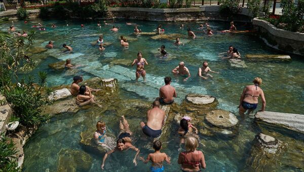 Tourists take a bath in a warm mineral water in the ancient city of Hierapolis built in the 2nd century BC and located 17 km off the city of Denizli, Turkey - Sputnik International