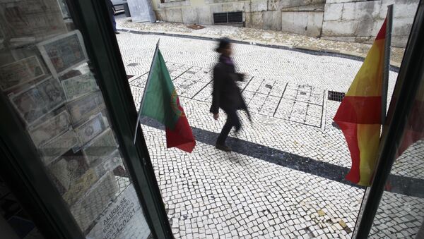 A woman walks past a coin collectors' shop with the flags of Spain and Portugal (File) - Sputnik International