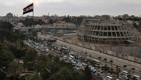 A Syrian national flag waves as vehicles move slowly in a traffic jam during rush hours on a road in Damascus , Syria (File) - Sputnik International