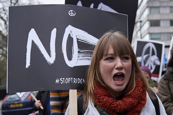 A protester shouts holding a placard as she marches in central London on February 27, 2016 in demonstration against a proposed renewal of Britain's Trident nuclear weapon system. A protester shouts holding a placard as she marches in central London on February 27, 2016 in demonstration against a proposed renewal of Britain's Trident nuclear weapon system. - Sputnik International