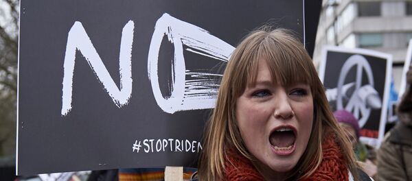 A protester shouts holding a placard as she marches in central London on February 27, 2016 in demonstration against a proposed renewal of Britain's Trident nuclear weapon system. - Sputnik International