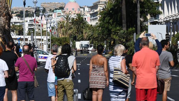 People look at a truck stand guarded by the police on the Promenade des Anglais seafront in the French Riviera town of Nice on July 15, 2016, hours after it drove into a crowd watching a fireworks display. - Sputnik International