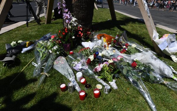A photo taken on July 15, 2016 shows flowers and candles placed near the site in Nice where a gunman smashed a truck into a crowd of revellers celebrating Bastille Day, killing at least 84 people. - Sputnik International