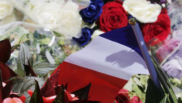 A bouquet of flowers and a French flag is seen as people pay tribute near the scene where a truck ran into a crowd at high speed killing scores and injuring more who were celebrating the Bastille Day national holiday, in Nice, France, July 15, 2016. - Sputnik International