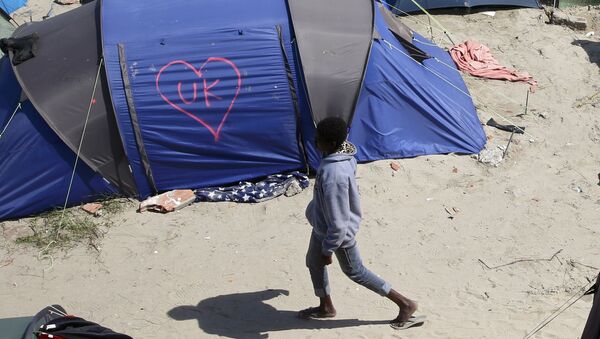 A heart and UK symbol are marked on the side of a tent as a migrant walks in the make-shift camp, called the jungle, in Calais, France, after Britain's referendum results to leave the European Union were announced June 24, 2016. - Sputnik International