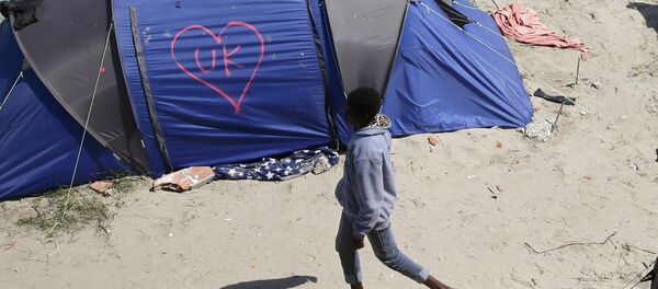 A heart and UK symbol are marked on the side of a tent as a migrant walks in the make-shift camp, called the jungle, in Calais, France, after Britain's referendum results to leave the European Union were announced June 24, 2016. - Sputnik International