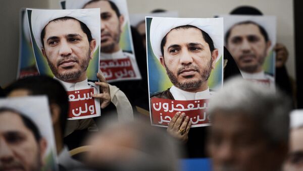 Bahraini men hold placards bearing the portrait of Sheikh Ali Salman, head of the Shiite opposition movement Al-Wefaq, during a protest on May 29, 2016 against his arrest, at Al wefaq headquarter building, in the village of Zinj on the outskirts of the capital Manama. - Sputnik International