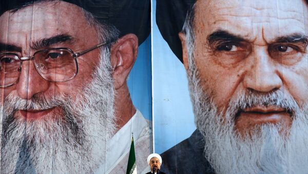 Iranian President Hassan Rouhani delivers a speech under portraits of Iran's supreme leader, Ayatollah Ali Khamenei (L) and Iran's founder of the Islamic Republic, Ayatollah Ruhollah Khomeini (R), on the eve of the 25th anniversary of the Islamic revolutionary leader Ayatollah Ruhollah Khomeini's death, at his mausoleum in a suburb of Tehran - Sputnik International