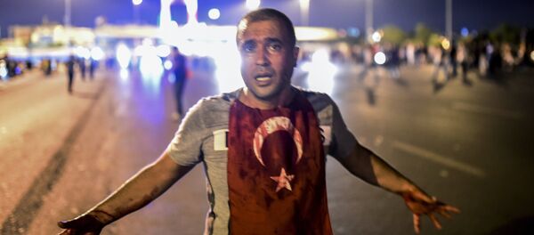 A man covered with blood stands near the Bosphorus bridge as Turkish military clash with people at the entrance to the bridge in Istanbul on July 16, 2016 - Sputnik International