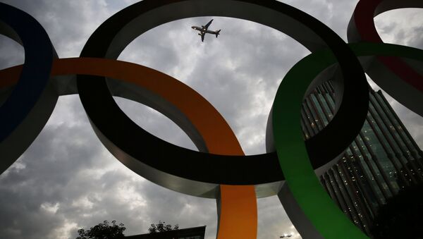 An airplane flies past Olympic rings placed at the entrance of office building ahead of the Rio 2016 Olympic Games, in Sao Paulo, Brazil, July 19, 2016 - Sputnik International