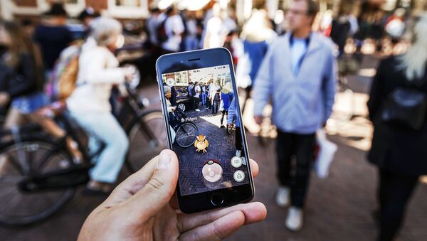 Gamers play with the Pokemon Go application on their mobile phone, at the Grote Markt in Haarlem, on July 13, 2016 - Sputnik International