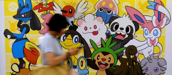 A woman using a mobile phone walks past a shop selling Pokemon goods in Tokyo, Japan July 20, 2016. - Sputnik International