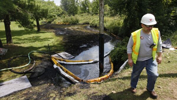 In this July 29, 2010 file photo, a worker monitors the water in Talmadge Creek in Marshall Township, Mich., near the Kalamazoo River as oil from a ruptured pipeline, owned by Enbridge Inc, is vacuumed out the water - Sputnik International