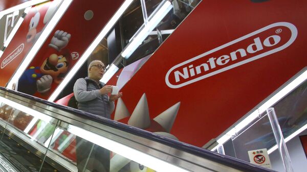 In this March 20, 2016, file photo, a shopper standing on an escalator passes by the Nintendo logo at an electronics store in Tokyo - Sputnik International