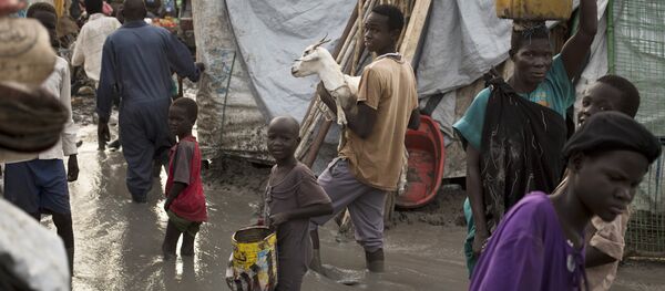 South-Sudanese man carries a goat as he and others wade through mud-filled paths between makeshift tents in the United Nations base (File) South-Sudanese man carries a goat as he and others wade through mud-filled paths between makeshift tents in the United Nations base (File) - Sputnik International