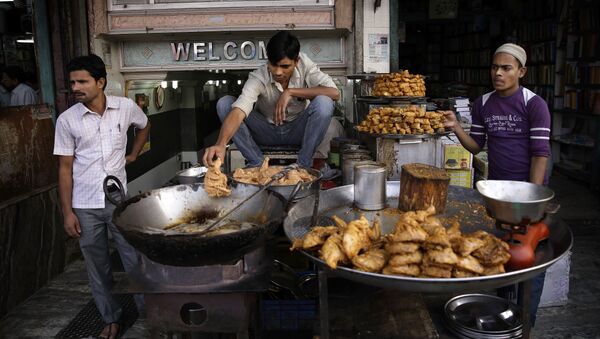 In this Tuesday, Nov. 12, 2013 photo, a cook uses his hand to release pieces of chicken into hot oil at a street side food joint in New Delhi, India - Sputnik International