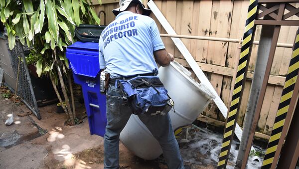 Miami-Dade mosquito control worker Carlos Vargas dumps a barrel of standing water that can incubate the Aedes aegypti mosquito larvae at a home in Miami, Florida, on June 08, 2016 - Sputnik International