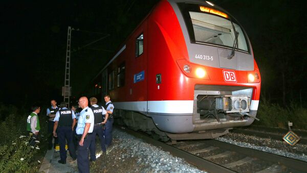 Police officers stand by a regional train in Wuerzburg southern Germany on July 18, 2016 after a man attacked train passengers with an axe - Sputnik International
