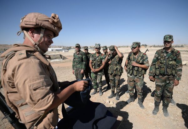 A Russian serviceman, left, trains Syrian soldiers to search and detect explosive devices in Palmyra. File photo - Sputnik International