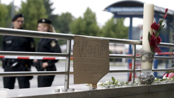 A sign reading 'Why' and flowers are placed on on a wall near the Olympia shopping mall, where yesterday's shooting rampage started, in Munich, Germany July 23, 2016. - Sputnik International