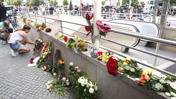 A women places flowers near the Olympia shopping mall, where yesterday's shooting rampage started, in Munich, Germany July 23, 2016. - Sputnik International