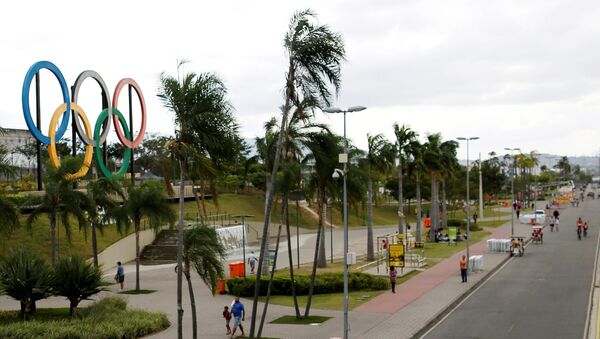 People walk near Olympic rings placed at Madureira Park ahead of the Rio 2016 Olympic Games in Rio de Janeiro, Brazil, July 17, 2016. - Sputnik International