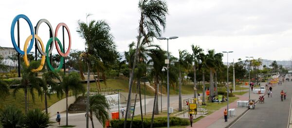 People walk near Olympic rings placed at Madureira Park ahead of the Rio 2016 Olympic Games in Rio de Janeiro, Brazil, July 17, 2016. - Sputnik International
