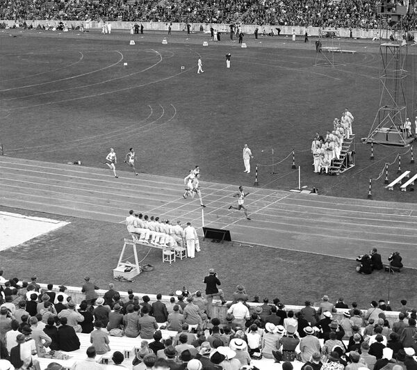 American Jesse Owens runs in 21.1 seconds to win his elimination heats in the Olympic 200-meter dash during the Berlin Olympics, August 8, 1936. (File) - Sputnik International