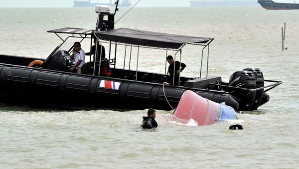 Malaysian Maritime Enforcement Agency (MMEA) enforcement officers retrieve a capsized boat (file) - Sputnik International