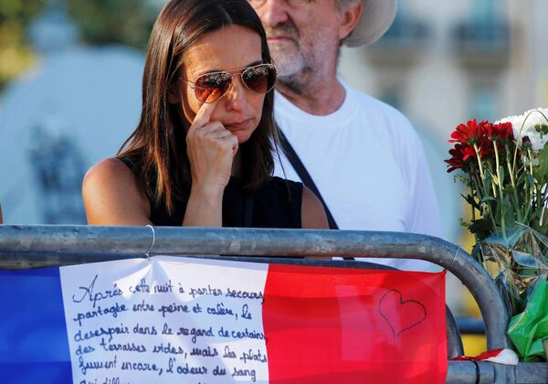A woman reacts near flowers and flags placed in tribute to victims, two days after an attack by the driver of a heavy truck who ran into a crowd on Bastille Day killing scores and injuring as many on the Promenade des Anglais, in Nice, France, July 16, 2016. A woman reacts near flowers and flags placed in tribute to victims, two days after an attack by the driver of a heavy truck who ran into a crowd on Bastille Day killing scores and injuring as many on the Promenade des Anglais, in Nice, France, July 16, 2016. - Sputnik International