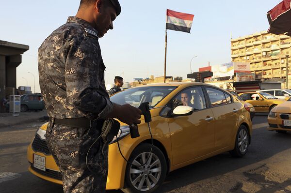 In this Thursday, July 14, 2016 picture, an Iraqi policeman uses a hand-held device that is supposed to detect bombs at a checkpoint in Basra, 340 miles (550 kilometers) southeast of Baghdad, Iraq.  - Sputnik International