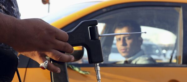 In this Thursday, July 14, 2016 picture, an Iraqi policeman uses a hand-held device that is supposed to detect bombs at a checkpoint in Basra, 340 miles (550 kilometers) southeast of Baghdad, Iraq. - Sputnik International