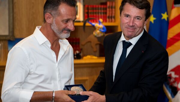 President of the Provence Alpes Cote d'Azur region and former Nice mayor Christian Estrosi (R) gives to Franck, one of the three 'heroes' of the July 14 attack in Nice, the city's medal at the City hall in Nice, southeastern France - Sputnik International