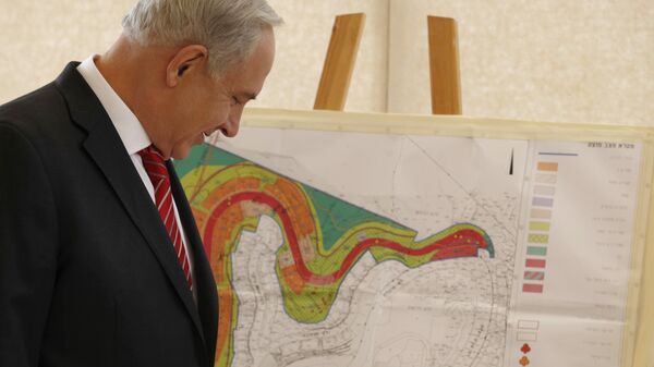 Israeli Prime Minister Benjamin Netanyahu looks at a map of the area where Israel plans to build some 800 new housing units during his visit to the east Jerusalem Jewish neighborhood of Gilo. - Sputnik International