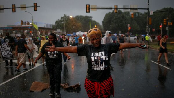 Black Lives Matter activists react to heavy rain fall as they gather to protest outside the site of the 2016 Democratic National Convention in Philadelphia, Pennsylvania July 25, 2016. - Sputnik International