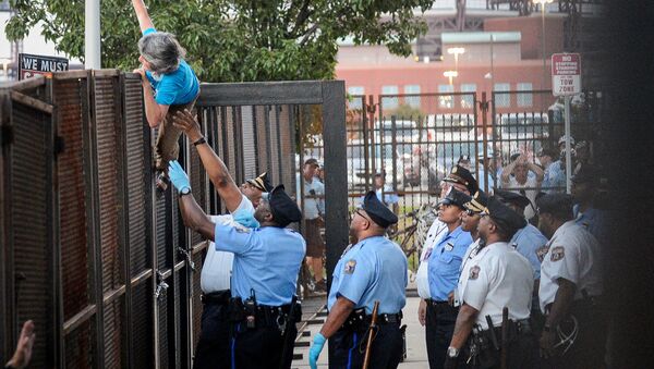 A protester is detained by police after climbing over a barrier near the site of the Democratic National Convention in Philadelphia, Pennsylvania, U.S., July 26, 2016 - Sputnik International