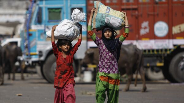 Indian child laborers carry sacks of vegetable leftovers collected from a wholesale market to be sold in their shantytown, on the World Day against Child Labor, on the outskirts of Jammu, India (File) - Sputnik International