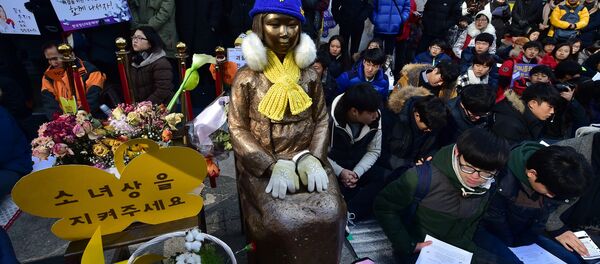 South Korean students sit near a statue (C) of a teenage girl symbolizing former comfort women who served as sex slaves for Japanese soldiers during World War II, during a weekly anti-Japanese demonstration in front of the Japanese embassy in Seoul (File) South Korean students sit near a statue (C) of a teenage girl symbolizing former comfort women who served as sex slaves for Japanese soldiers during World War II, during a weekly anti-Japanese demonstration in front of the Japanese embassy in Seoul (File) - Sputnik International