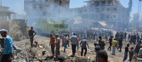 Smoke rises while people gather at a damaged site after two bomb blasts claimed by Islamic State hit the northeastern Syrian city of Qamishli near the Turkish border, Syria July 27, 2016 - Sputnik International