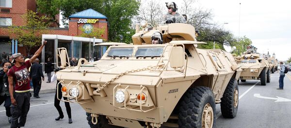 Police armoured cars drive down a Baltimore street as people begin to celebrate in Baltimore, Maryland May 1, 2015 following the decision to charge six Baltimore police officers -- including one with murder -- in the death of Freddie Gray - Sputnik International