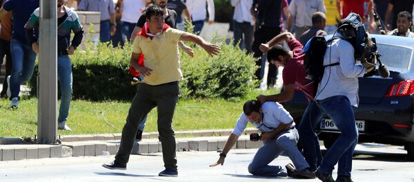 Supporters of Turkey's President Recep Tayyip Erdogan, who were staging a protest against a coup, clash with Turkish journalists near the Turkish military headquarters, in Ankara, Turkey, Saturday, July 16, 2016 - Sputnik International