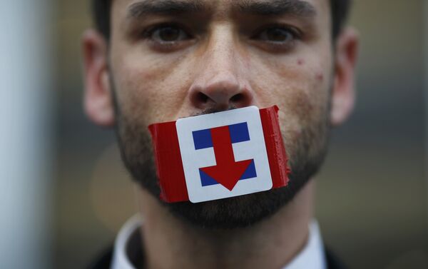 A former Bernie Sanders delegate wears a Hillary Clinton presidential campaign sticker over his mouth as he protests during the third session at the Democratic National Convention in Philadelphia, Pennsylvania, U.S. July 27, 2016. - Sputnik International