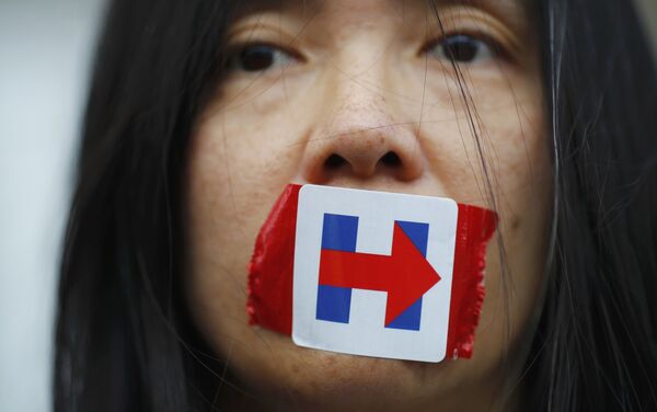 A former Bernie Sanders delegate wears a Hillary Clinton presidential campaign sticker over her mouth as she protests during the third session at the Democratic National Convention in Philadelphia, Pennsylvania, U.S. July 27, 2016. - Sputnik International
