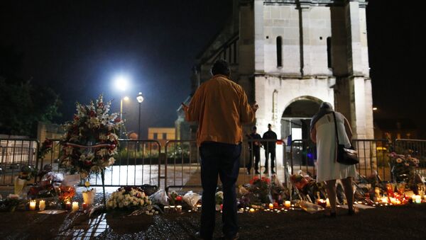 People stand in front of a makeshif memorial near two gendarmes guarding the Saint-Etienne du Rouvray church on July 27, 2016, after the priest Jacques Hamel was killed on July 26 in the church during a hostage-taking claimed by Islamic State group - Sputnik International