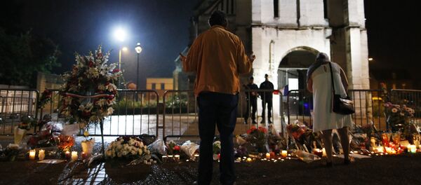 People stand in front of a makeshif memorial near two gendarmes guarding the Saint-Etienne du Rouvray church on July 27, 2016, after the priest Jacques Hamel was killed on July 26 in the church during a hostage-taking claimed by Islamic State group - Sputnik International